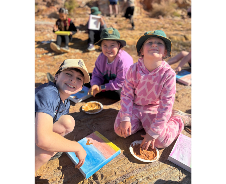 Students sit together outside, enjoying a meal and engaging in learning during an excursion, exploring new environments and connecting their classroom learning with the wider world.